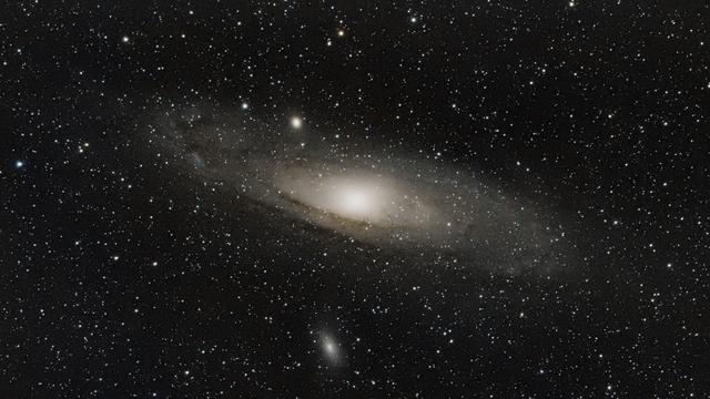 the famous Andromeda galaxy (m31) with also m110 in the shot. Large spiral galaxy with bright bulb and visible stripes of dark gases. Lots of stars in the background (but in fact, in the foreground)