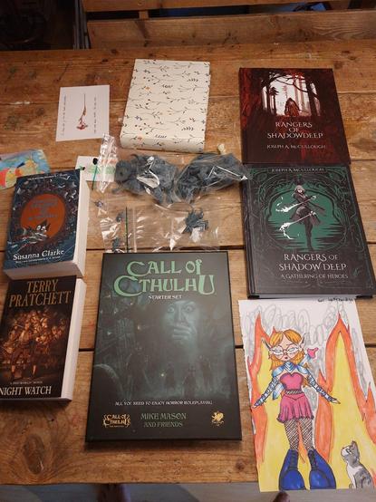 Handmade birthday card, tiny hand painted canvas with a paint pot and makeup brush, rangers of shadow deep rulebook, rangers of Shadow deep 'a gathering of heroes' supplement, family photo album, 11yo's self portrait as a warrior elf, call of cthulhu starter set, three gnome models, two giant Minotaur models, Terry Pratchett's discworld 'the night watch', Susanna Clarke's 'Jonathan Strange & Mr Norell', and a photo album of me and my girls