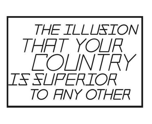 The image features a black and white graphic with a rectangular border. Inside the border, there is a block of text in a bold, sans-serif font. The text is arranged in a staggered format, with each line slightly offset from the one above it. The text reads: "THE ILLUSION THAT YOUR COUNTRY IS SUPERIOR TO ANY OTHER." The font is uniform throughout, with no additional graphics or colors. The background is plain white, which contrasts sharply with the black text, making it stand out prominently. The overall design is simple and direct, focusing solely on the message conveyed by the text.