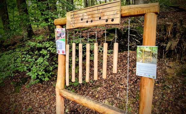 Auf einem kurzen Wanderrundweg wurden an verschiedenen Stellen Geräte aufgebaut, die Klänge erzeugen. Im Bild ein Gestell mit Hölzern verschiedener Längen, die aufgehängt wurden und mit einem weiteren Schlägelholz zum Klingen gebracht werden können.