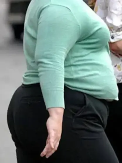 A heavier woman with bigger belly shown from a side, with her hand and fingers pointing down