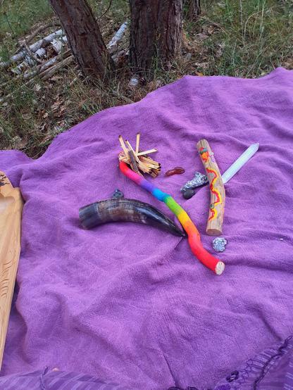 Ritual tools on a blanket like stones pieces of wood a horn etc
