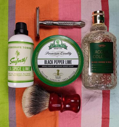 (Le Chat Mistral description)

The image showcases a collection of grooming products arranged on a striped background. At the top left, there is a bottle of Sea Spice Lime aftershave toner. In the centre, there is a round tin of Stirling Soap Co. Black Pepper Lime shaving soap. To the right, there is a bottle of Acqua Colonia with a textured, diamond-patterned design. Below the shaving soap, there is a shaving brush with a red handle. Above the aftershave toner, there is a small metal grooming tool. The items are neatly laid out, suggesting a well-organised grooming routine.