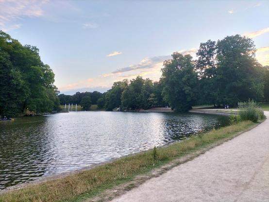 A peaceful lake flanked by trees, at dusk