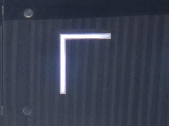 Светящаяся тонкая буква L на тёмном фоне, перевёрнутая по вертикали. // A lighting thin letter L on a dark background, inverted vertically and similar to the letter Г (Cyrillic G).