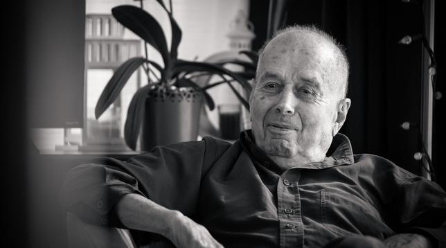 Black and white picture of an old man sitting in an armchair.