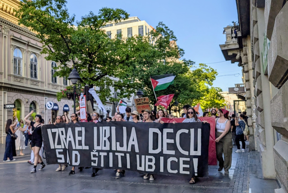 Protest walk through a street in the Belgrade's center, with Palestinian flags and front ribbon that says "Israel is mudering children"