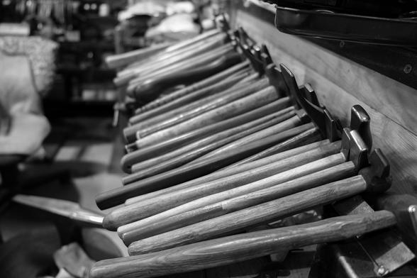 Black-and-white photograph of a row of hammers with wooden handles. Metal workshop, Faculty of Art and Design, Tsinghua University, Beijing, 26 June 2024. Photo Cindy Kohtala