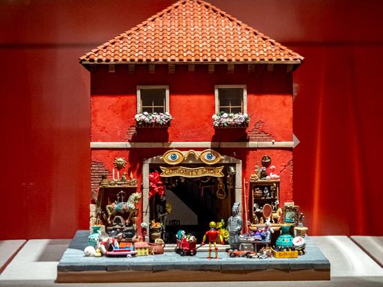A model of house/structure that has small toy and toy figures dispersed at the bottom.