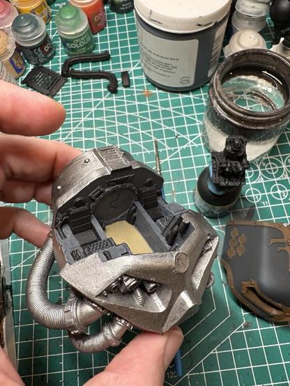The head of the reaver Titan. It is a very shiny metallic color. The interior walls are gray. The floor is beige.