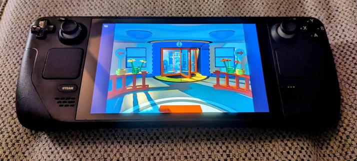 A photo of a Steam Deck laying on a couch, with the screen displaying Lego Island being played on it.  this time the in-game camera is focused on the main information center's rotating doorway entrance.