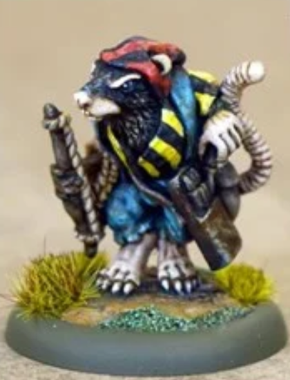 We have a 28mm anthropomorphic black rat miniature. He's dressed as a pirate with a yellow and black striped tunic, blue denim dungarees and a red and black striped bandana. He's unholstering a blunderbuss with his left hand and holding a stick with some rope in his right.