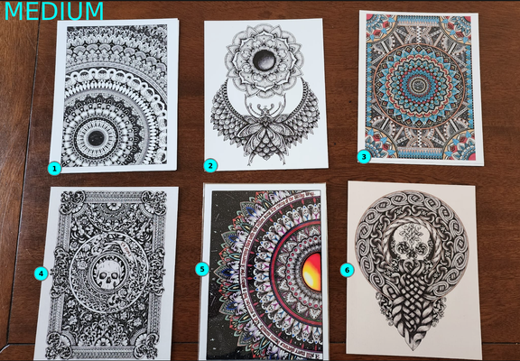 Six 'Medium' prints laid out on a table, numbered one to six left to right. There's a mix of black ink line art and black and colour mandalas, and celtic knotwork.