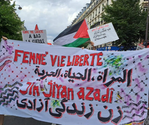 A banner reading "Jin Jiyan Azadi" in several languages.