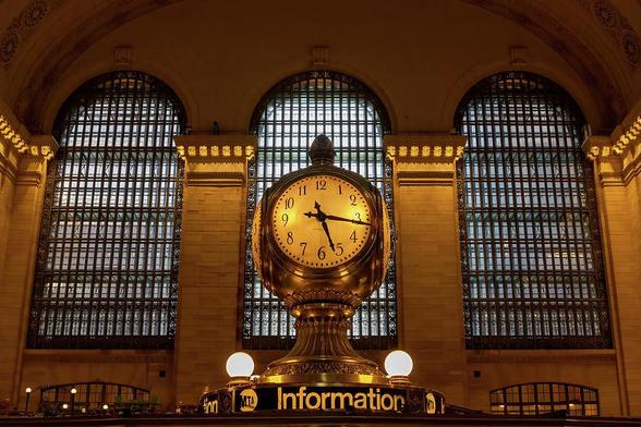Amidst the bustling heart of New York City lies the iconic Grand Central Station. As you gaze up towards the awe-inspiring ceiling, your eyes are drawn to the three colossal windows, the large four-way clock, and the information sign that bathe the station's interior in a warm, natural glow.