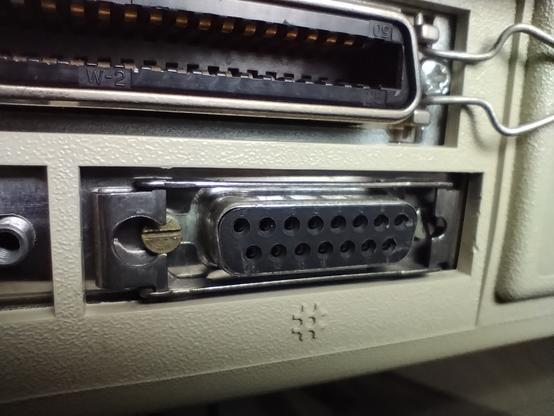 Two connectors on the backside of the VAXstation can be seen. On the upper part of the image is the external SCSI connector and on the lower part is the D-Sub AUI network connector.