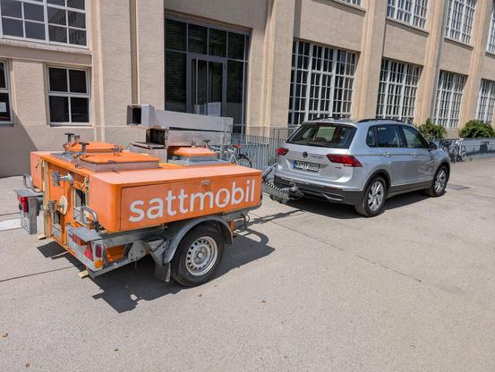 Orangene gulaschkanone an ein Auto gehängt