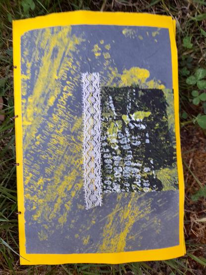 The back side of the art book: yellow maize cobble print on blue krafft paper, a piece of a yellow-white maize print on black tissue paper, fixed as a contrast with a stripe of white lace (sewn with yellow thread.)