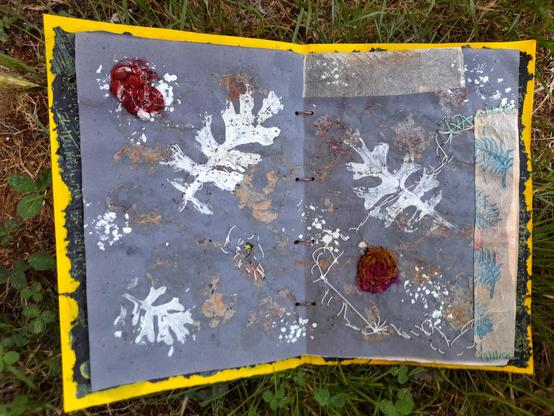 #4: white prints of fearn-like leaves on blue krafft paper. Abstract collage with used tea bag paper at the borders (one printed with a fern stamp) and spirals of reddish silk threads. Some abstract intuitive embroidery stitches made with extremely thin white paper yarn.