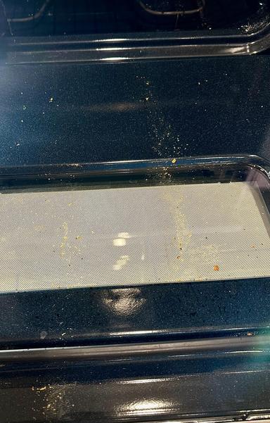 Same oven as in previous photo, but now the orange line of enzyme cleaner is wiped away leaving the middle of the oven clean. It’s subtle but to the right you still see the speckles of grease. This is after photo.