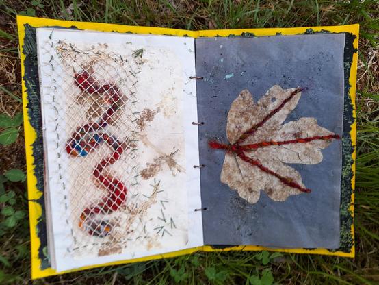 #9 abstract collage. Left: grey krafft paper with a snake of silk yarns, in all red and some blue shades. It's covered by a beige net (scap of an old dress), fixed with grey stitches. Right: blue krafft paper with a real maple leaf. The main leaf veins are covered with a line of the silk threads, fixed with finest black paper yarn.