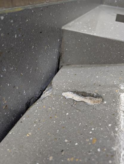 A deep groove eroded into a sink by a soap dispenser