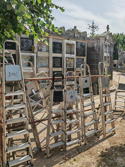 A row of stepladders in front of an array of tiered burial niches