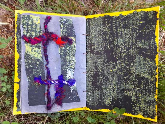 #15 The last page is a collage of a double cross of silk threads in a red- and blue mixture (the stitches backside are on '14). The fibre crosses connect 2 columns of the black printed paper. The right is the cover cardboard covered with black tissue paper. Printed in white and yellow with maize cobs.