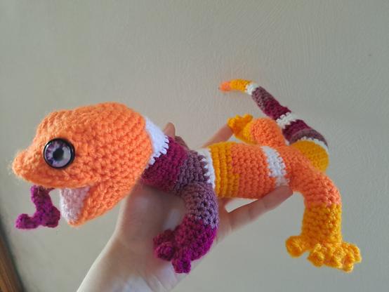 Salamandre au crochet, bouche ouverte : alternances de bandes orange foncé, orange clair, blanc, violet clair, violet.