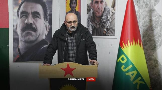 Photography of PJAK co-chair Emir Kerimî giving a speech with martyrs photos and Abdullah Öcalan photo and PJAK flag