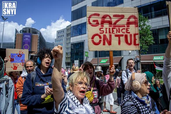 Des manifestantes, une dame tend le poing vers le ciel, derrière elle une pancarte "GAZA SILENCE ON TUE"