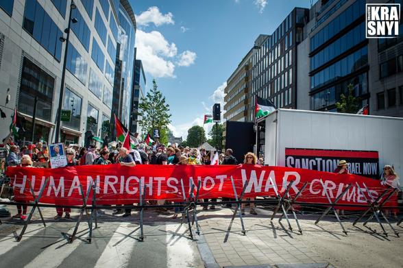 La foule des manifestan.te.s se masse derrière une barricade de la police. Un immense calicot avec ces mots: "HUMAN RIGHTS NOT WAR CRIMES"