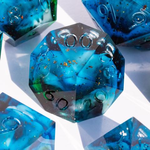 A D10 surrounded by other TTRPG dice. The dice are translucent light blue with swirls of white and green and have reflective bronze specks in them.