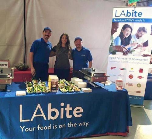 Photo d'un stand de "LAbite", un service de livraison de repas à Los Angeles. La caption "Your food is on the way"