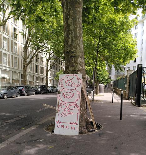 Porte gribouillée de têtes superposées, abandonnée dans la rue contre un arbre pour être jetée.