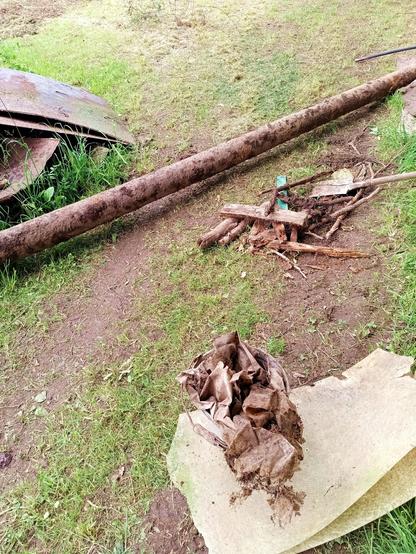 Some of the junk that came up in this job. There's the Nordstream pipeline, a bucket with dirty and decaying plastic sheeting and other junk and a pile of wood scraps and roots. A plastic pipe is visible at the far end.