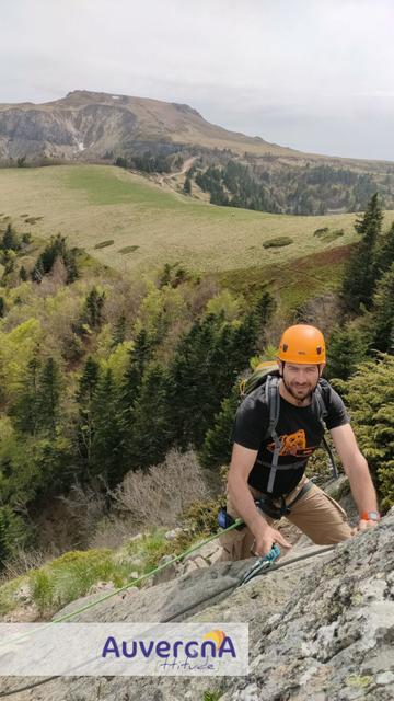 Homme engagé sur la via-ferrata du Capucin (Mont-Dore 63240), avec vue sur le puy de Cliergue (sommet du massif du Sancy).