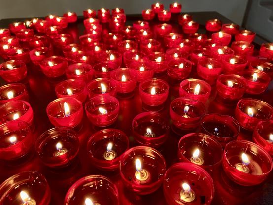 Rote Opferlichter in einer Kirche