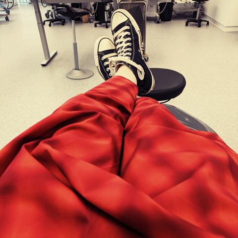 POV-Aufnahme auf einen rot gemusterten Rock und schwarze Chucks