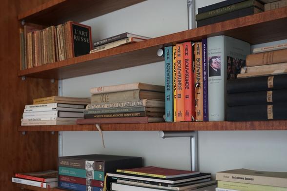 Rayonnages de bibliothèques au style épuré, garnis entre autres de livres sur l'architecture.