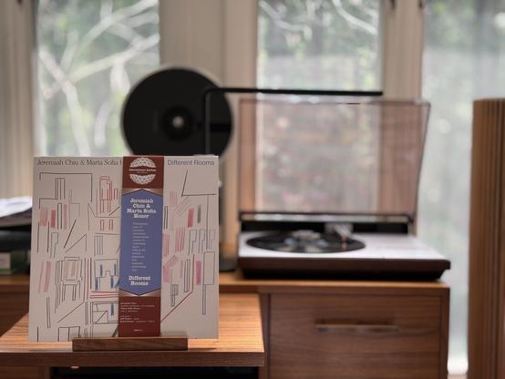 Jeremiah Chiu & Marta Sofia Honer - Different Rooms LP cover.

Well, a bunch of lines, folks. There's an OBI down the middle (just because of where it is) that shows the album information.

The black LP plays on a vintage, restored Bang & Olufsen Beogram 4000 linear-tracking turntable to the right.
