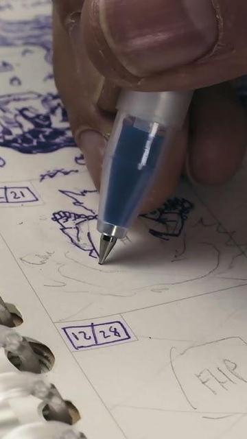 close up of a hand drawing a kobold monk character sitting cross legged