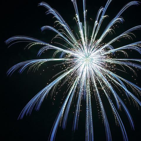 A vibrant firework bursting in the night sky, displaying long, trailing blue and white streaks with shimmering sparks.