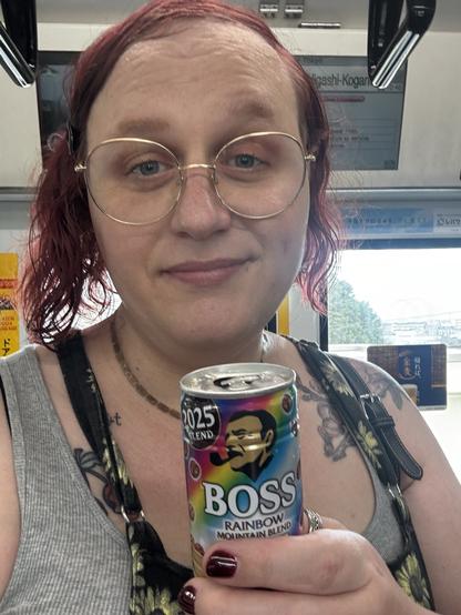 Picture of me smirking while holding up a rainbow colored can of Boss coffee
