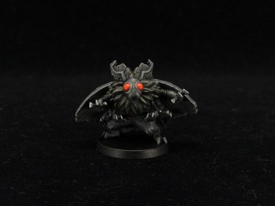 Painted mothman mini with red eyes, black fur, and gray highlights.
