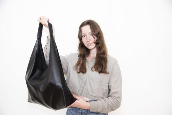 Foto van Floren die een zwarte tas omhoog houdt