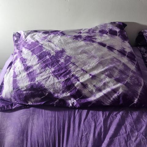 a pillowcase: the dye runs in regular diagonal streaks while very thin pale circles run from one corner like rings of a trees