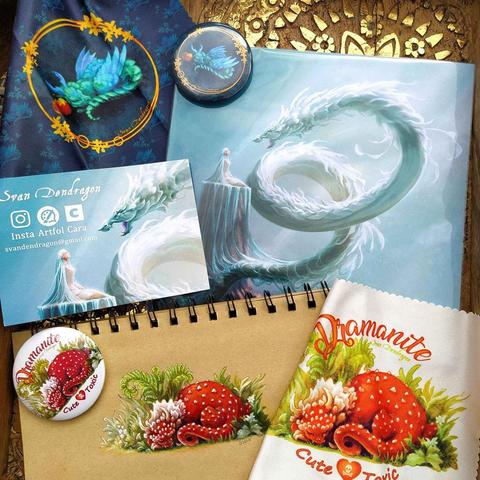 Photos montrant un lot de goodies avec mes dessins :
le print de "Chevelure" (l'enchanteresse et le dragon)
des badges et des tissus essuie lunettes avec deux de mes dragons, le Dramanite et le Dragopomme.