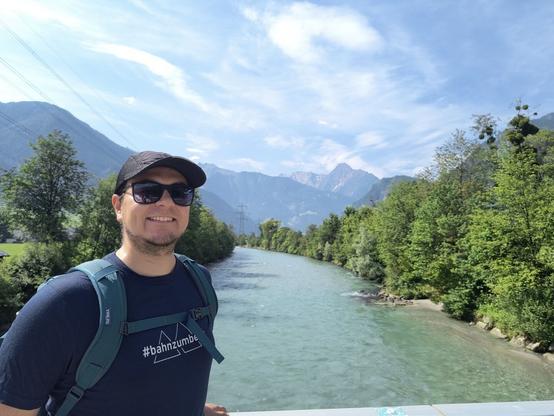 I am standing on a bridge. The Ziller river flows under the bridge towards the far back mountains.