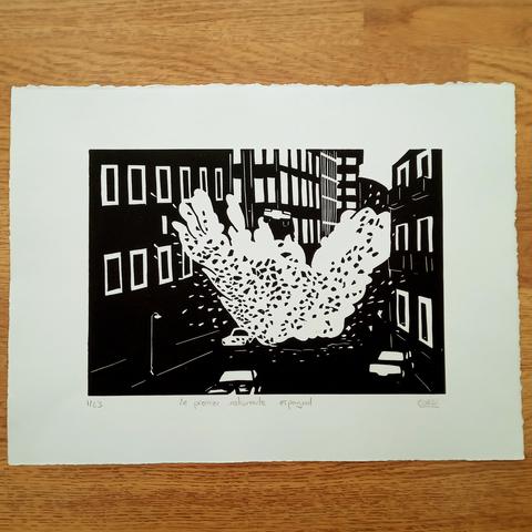 Photo globale d'un tirage de ladite linogravure.
Un noir et blanc franc, en masses.
Au centre, l'explosion de la voiture, en blanc, tachetée de débris noirs.
Autour, la voiture qui vole, les bâtiments alentour et quelques autres voitures au sol.